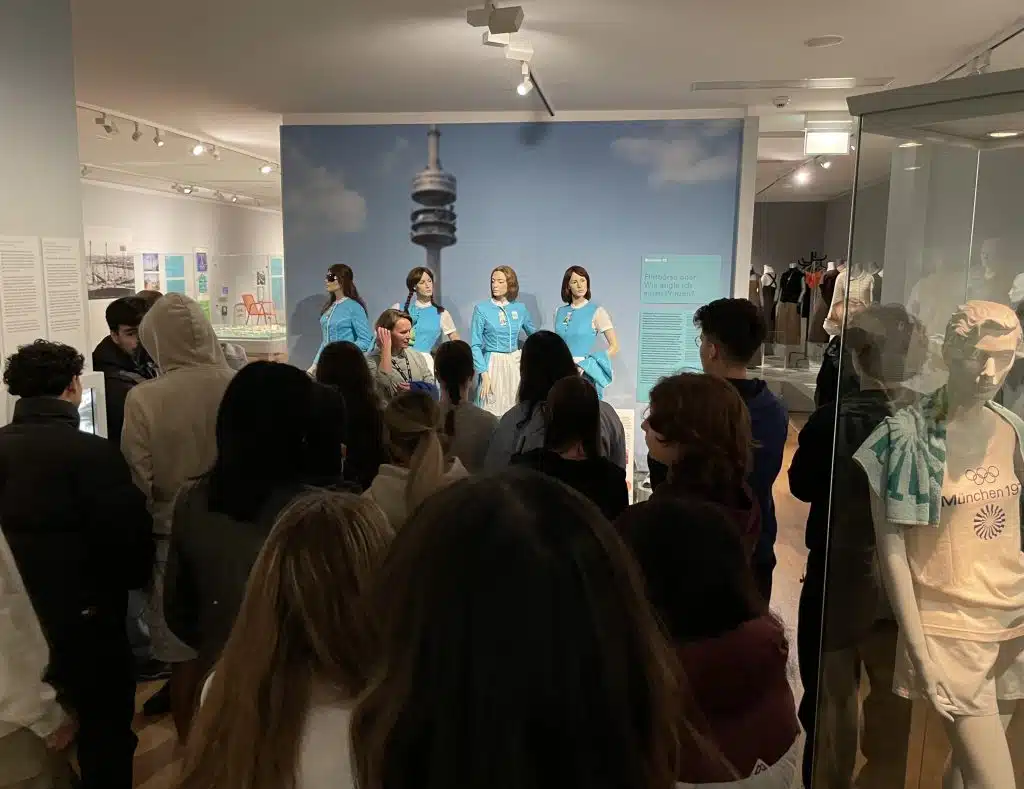 Eine Führung von Schüler*innen in der Ausstellung "Mode, Menschen und Musik" des Münchner Stadtmuseums, im Rahmen des Projekts München 72